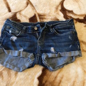Dark blue slightly ripped jean shorts.
